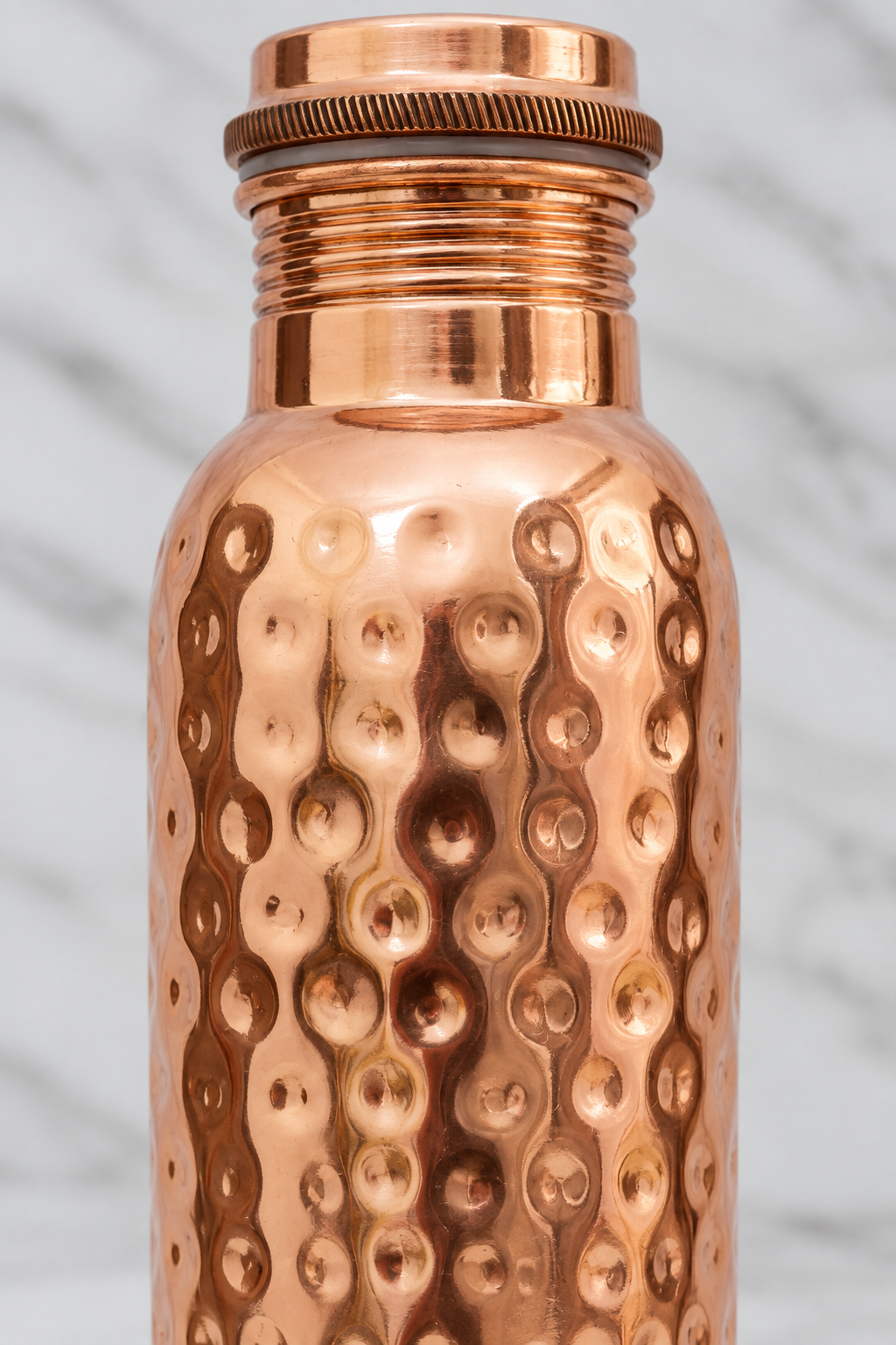 Close detail of the screw-in lid and hammered surface of the copper bottle