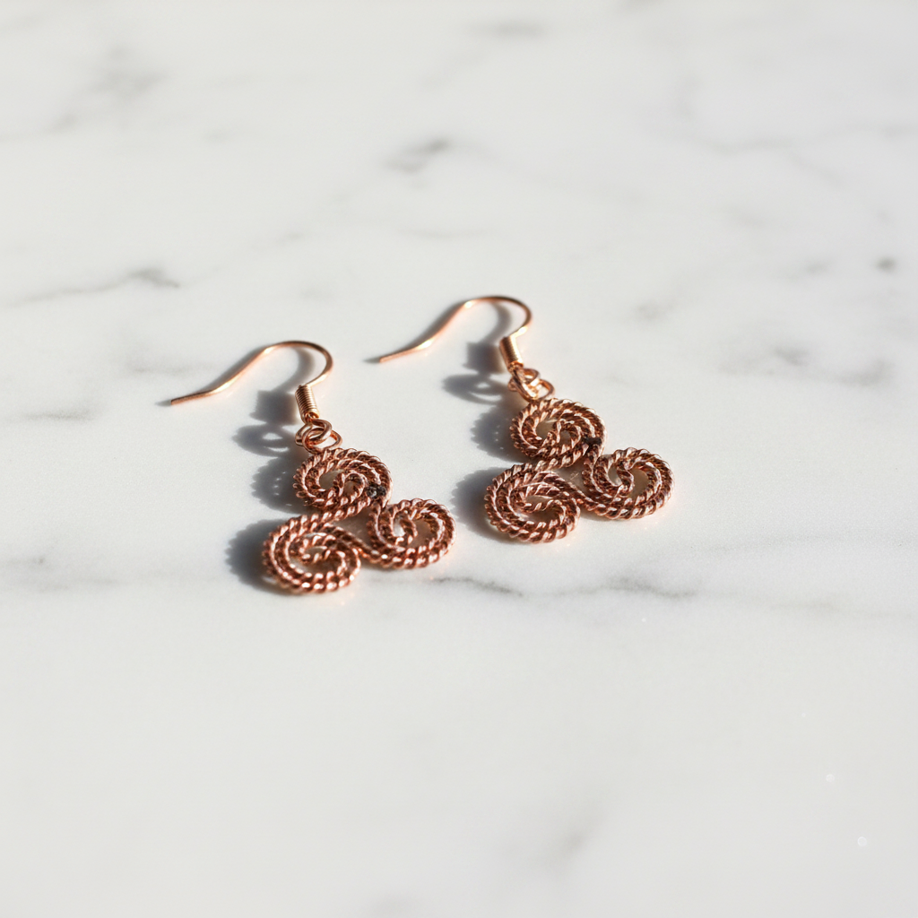 Triskelion copper earrings on white marble