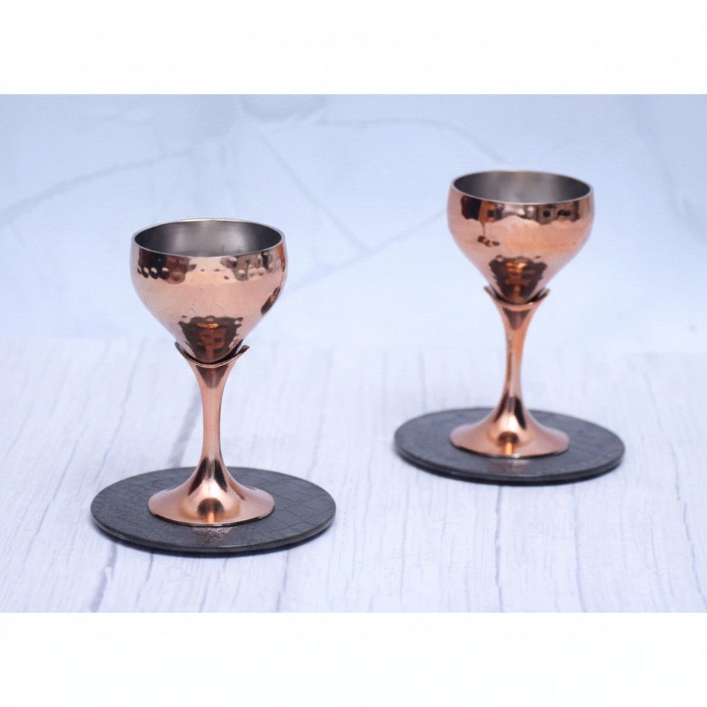 Two copper goblet glasses on white marble