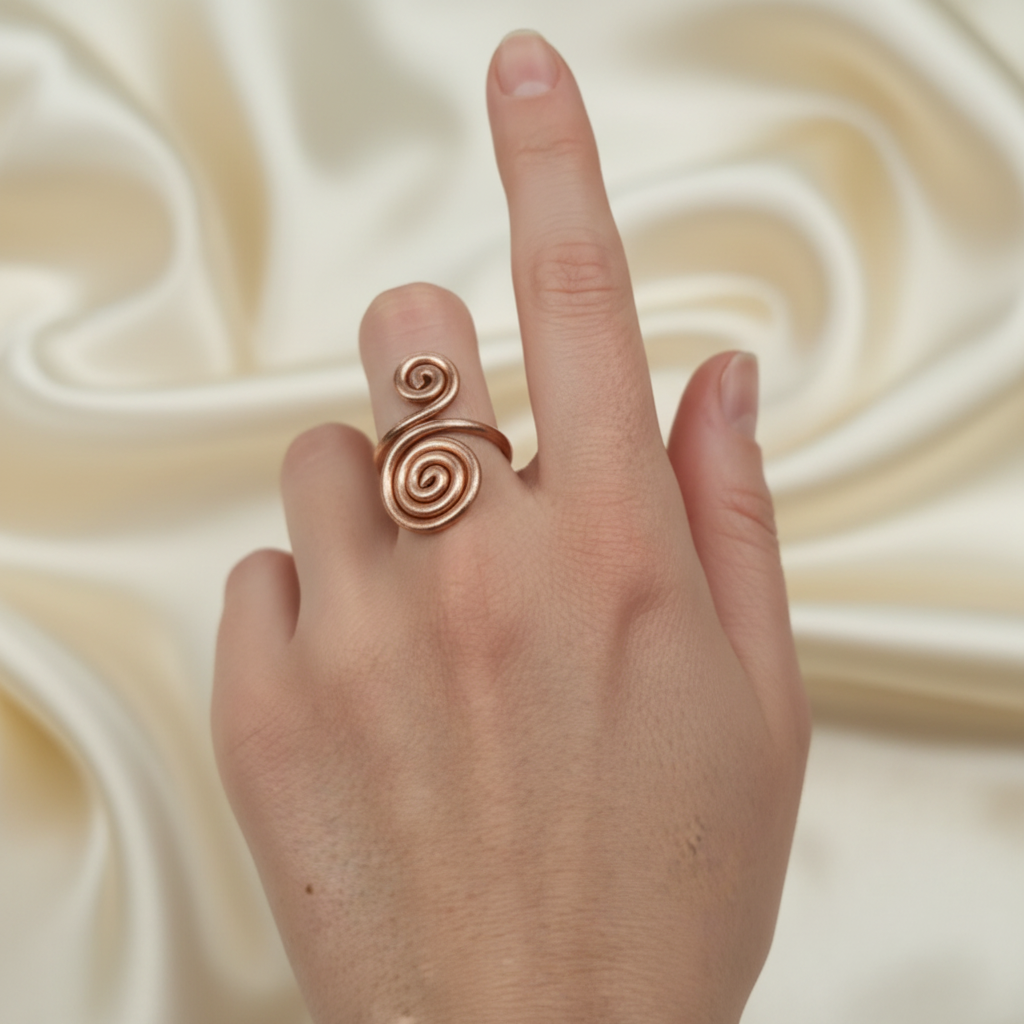 Copper spiral ring on fair skin hand with silk