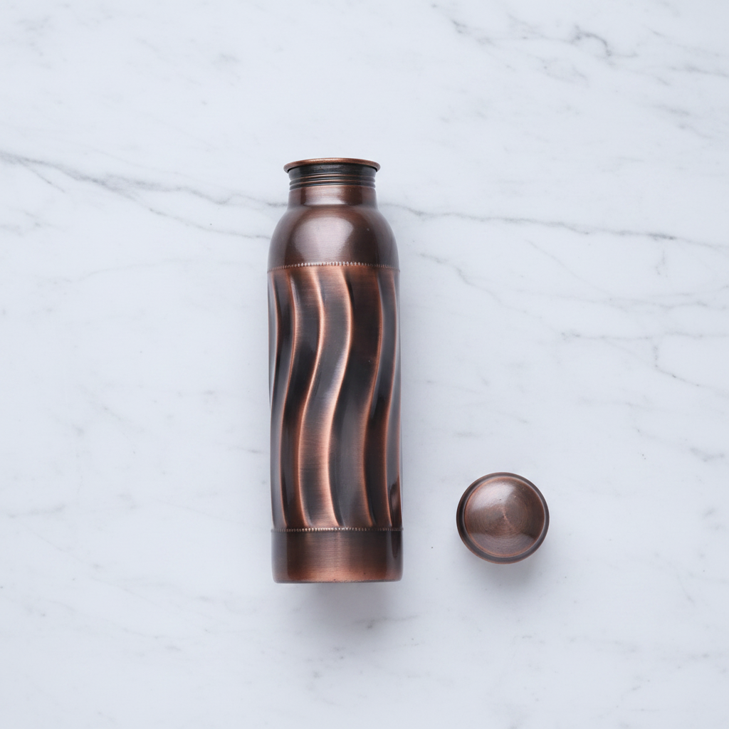 Antique swirl copper bottle flat lay on white marble