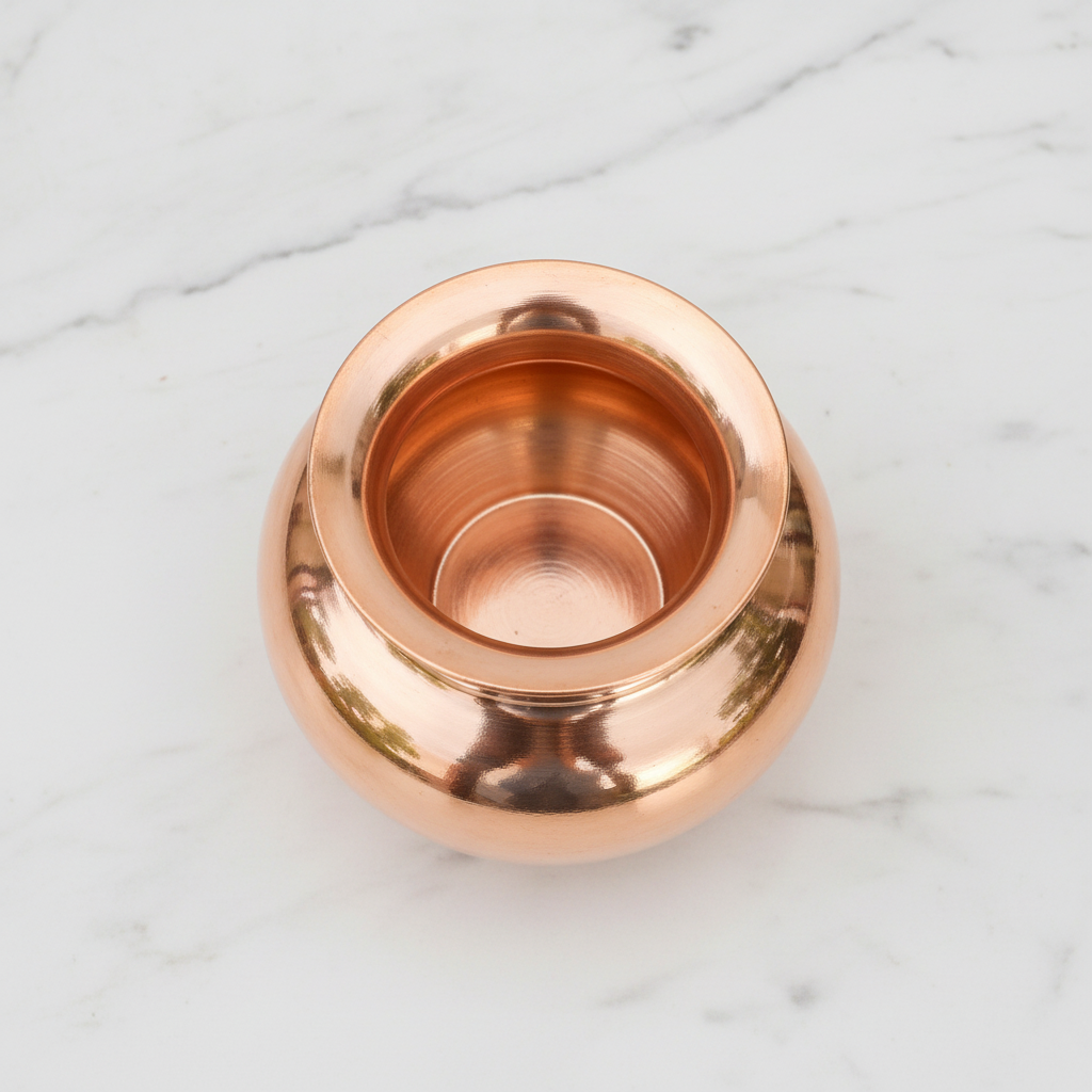 Copper lota top-down view on white marble